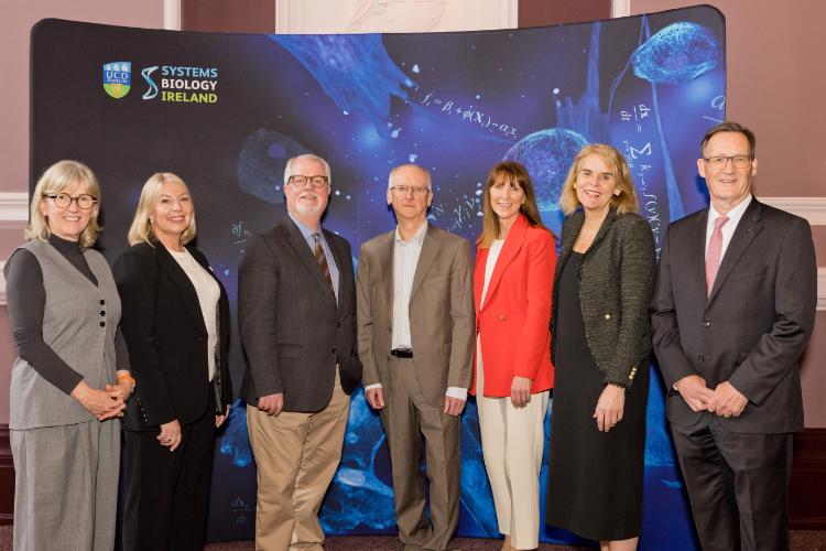 a group of adults in front of a blue banner